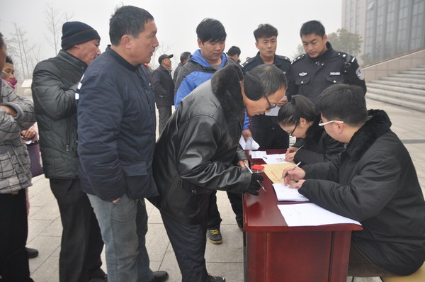 图为安徽省淮北市烈山区人民法院的法官在室外向职工发放经济补偿金二.JPG