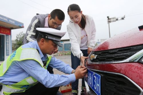 10月1日，交警四大队民警在宋疃卡点为路过车辆装上新牌照